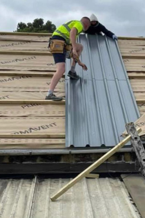 Two men working on commercial or industrial corrugated roof